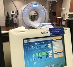 CT contrast injector data screen in a control room with the CT scanner in the background, at Northwestern Medicine Central DuPage Hospital.