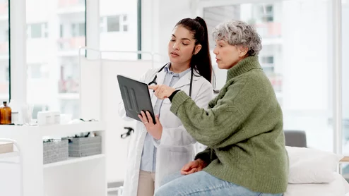 old woman or doctor shaking hands with patient